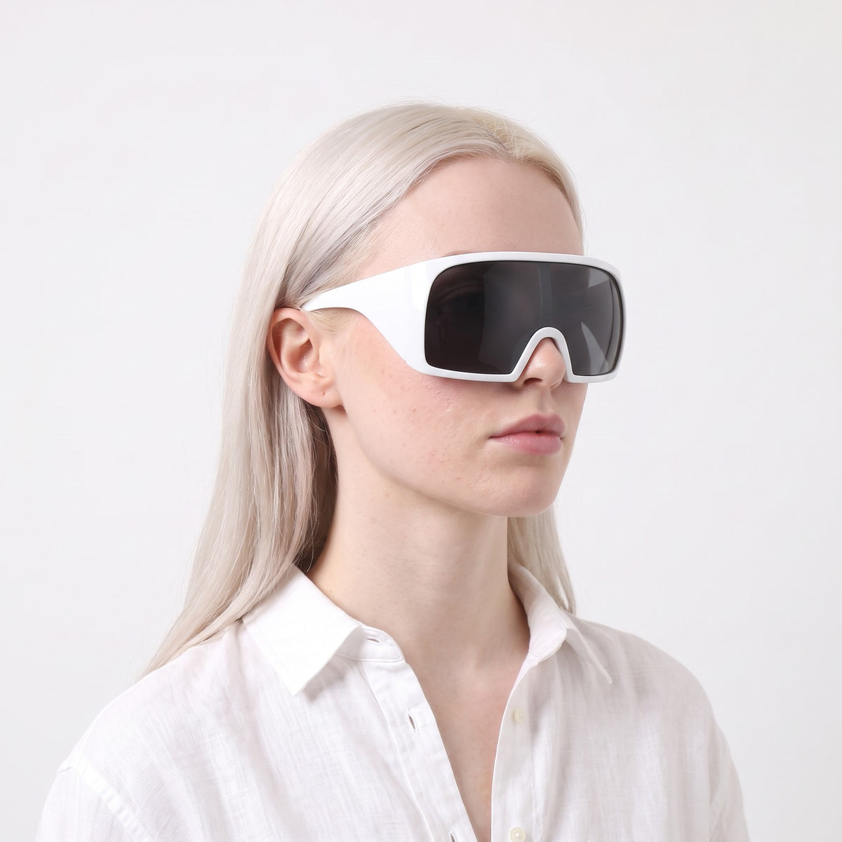 Woman in a white linen shirt wearing Berlin wrap shield sunglasses with glossy white frame and grey lens — Velezeco #opt1_3