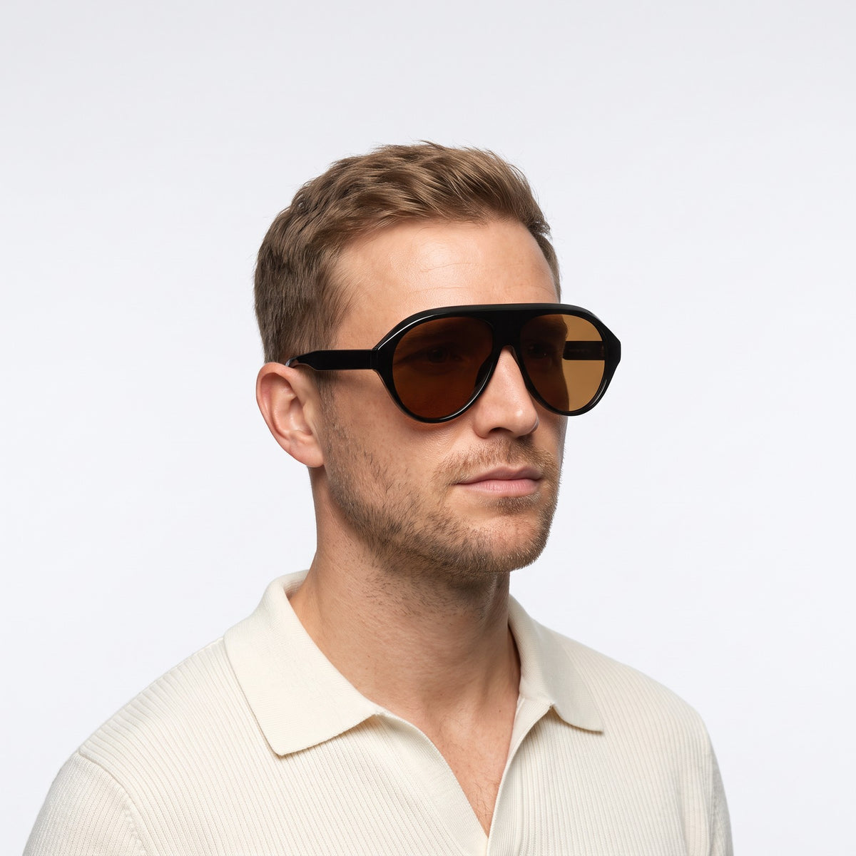 Man in a cream knit polo wearing Boston black oversized aviator sunglasses with brown lenses · Velezeco #opt1_1