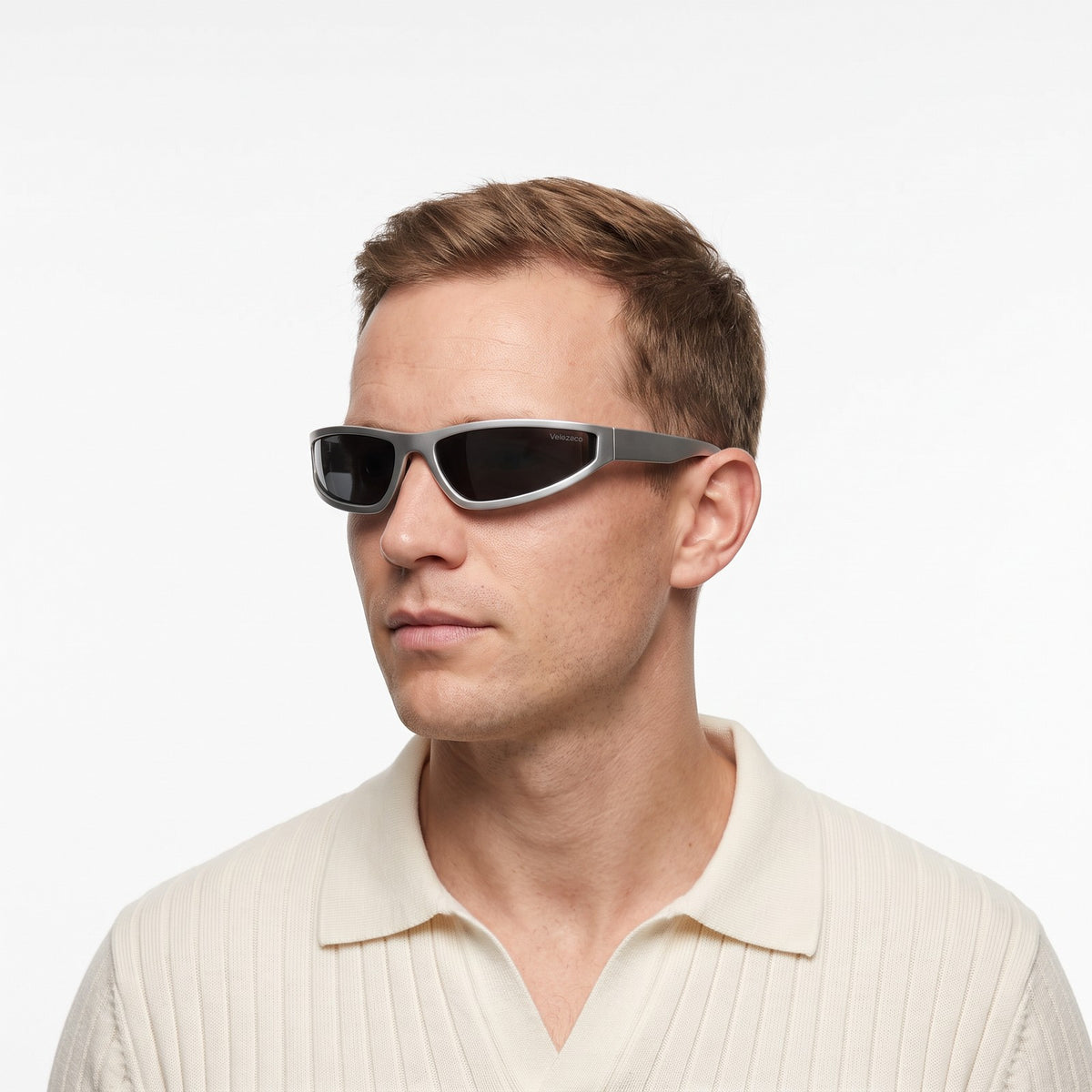 Man in a cream knit polo wearing Dax silver-grey wraparound sunglasses with dark grey lenses · Velezeco #opt1_2
