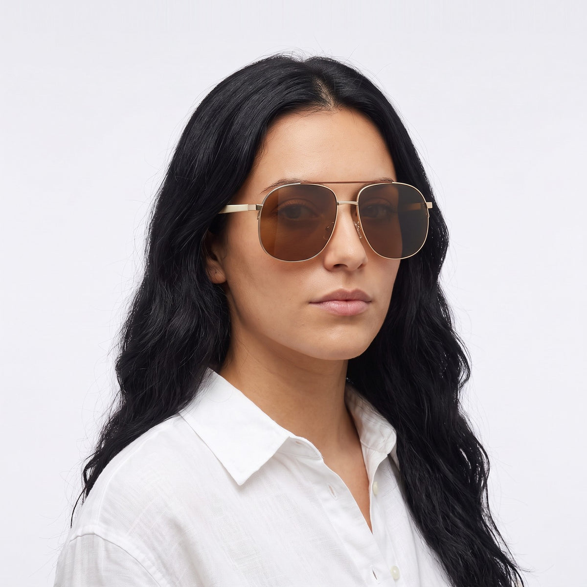 Woman in a white linen shirt wearing Dubai aviator sunglasses with gold double bridge and brown lenses — Velezeco #opt1_2