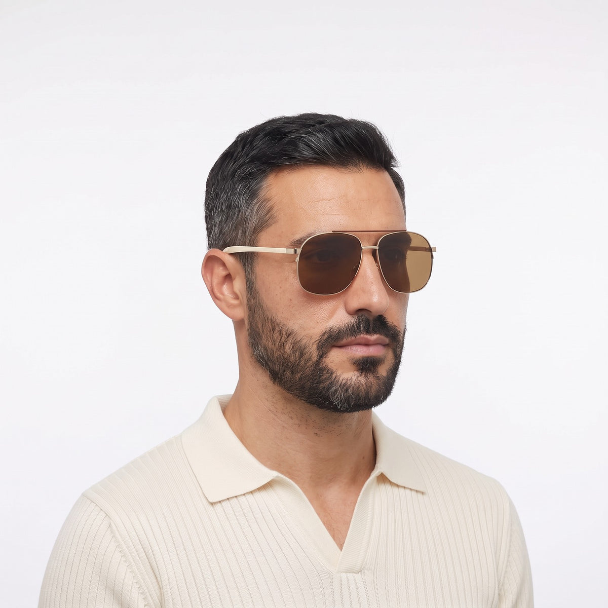 Man in a cream knit polo wearing Dubai aviator sunglasses with gold double bridge and brown lenses — Velezeco #opt1_2