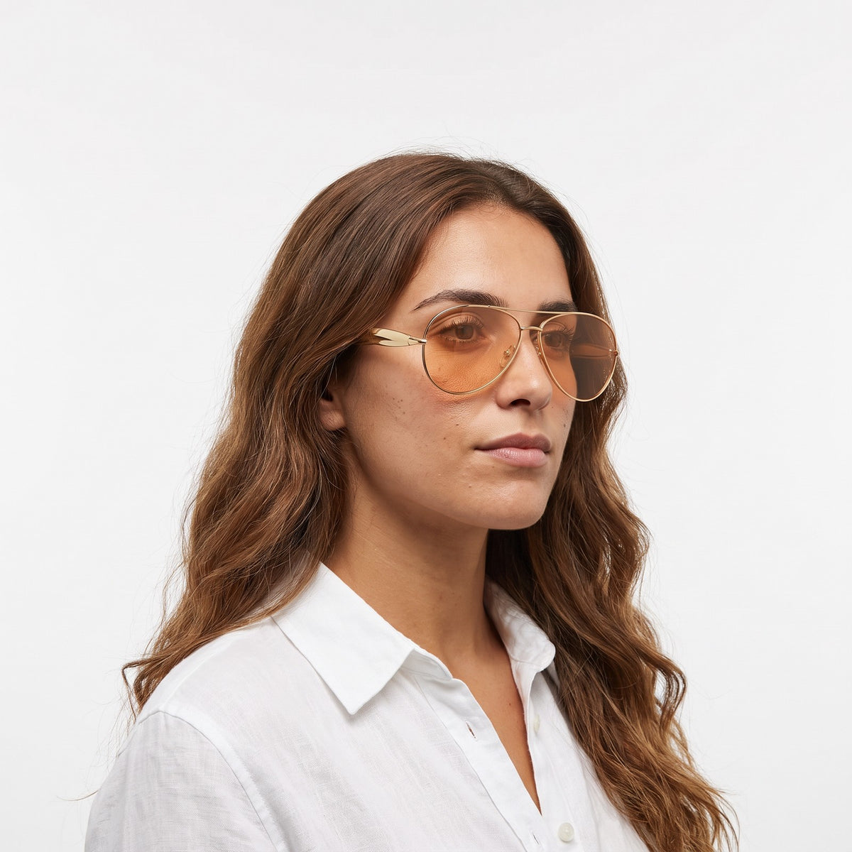 Woman in a white linen shirt wearing Duna gold aviator sunglasses with orange lenses · Velezeco #opt1_5