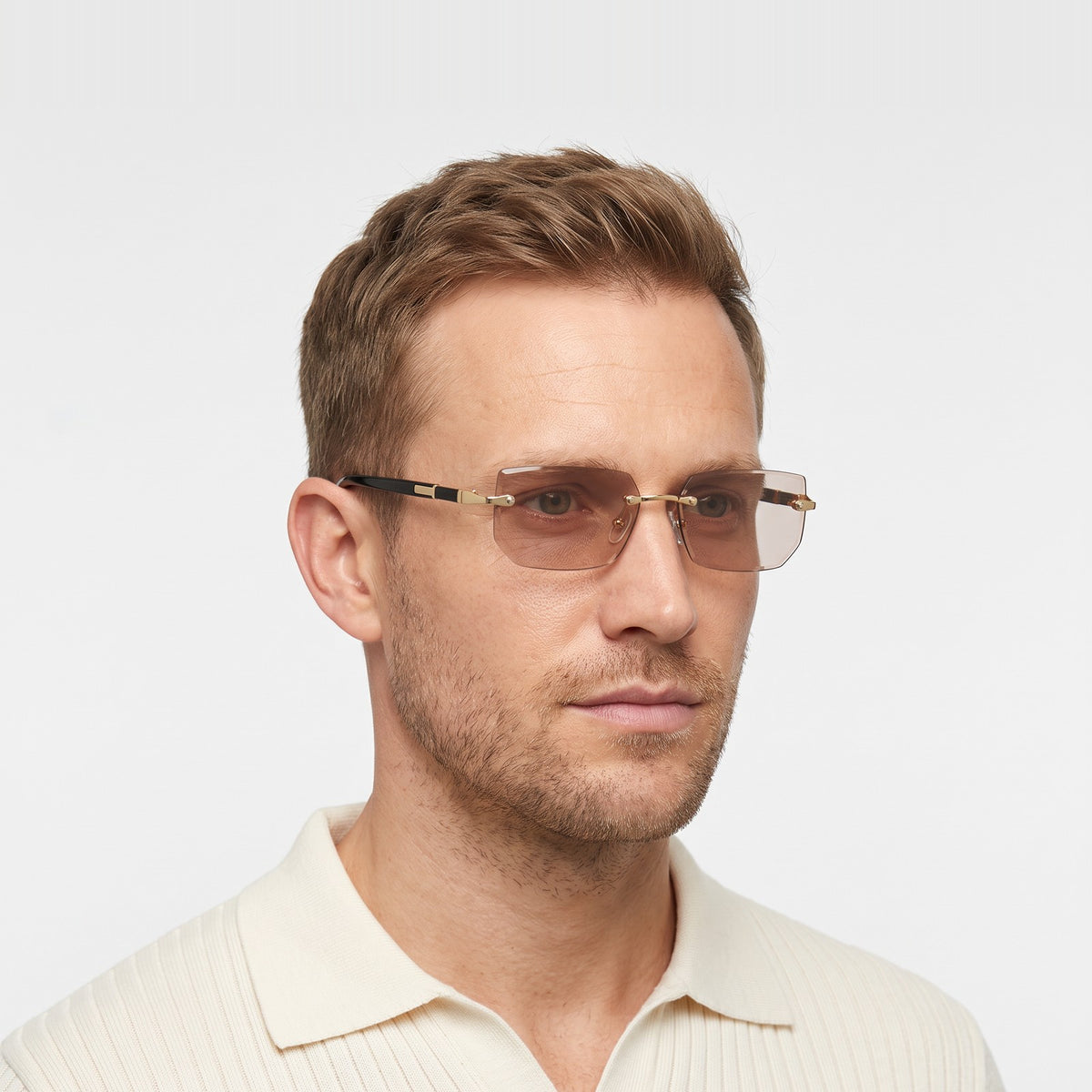 Man in a cream knit polo wearing Hills rimless rectangular sunglasses with clear brown lenses · Velezeco #opt1_1