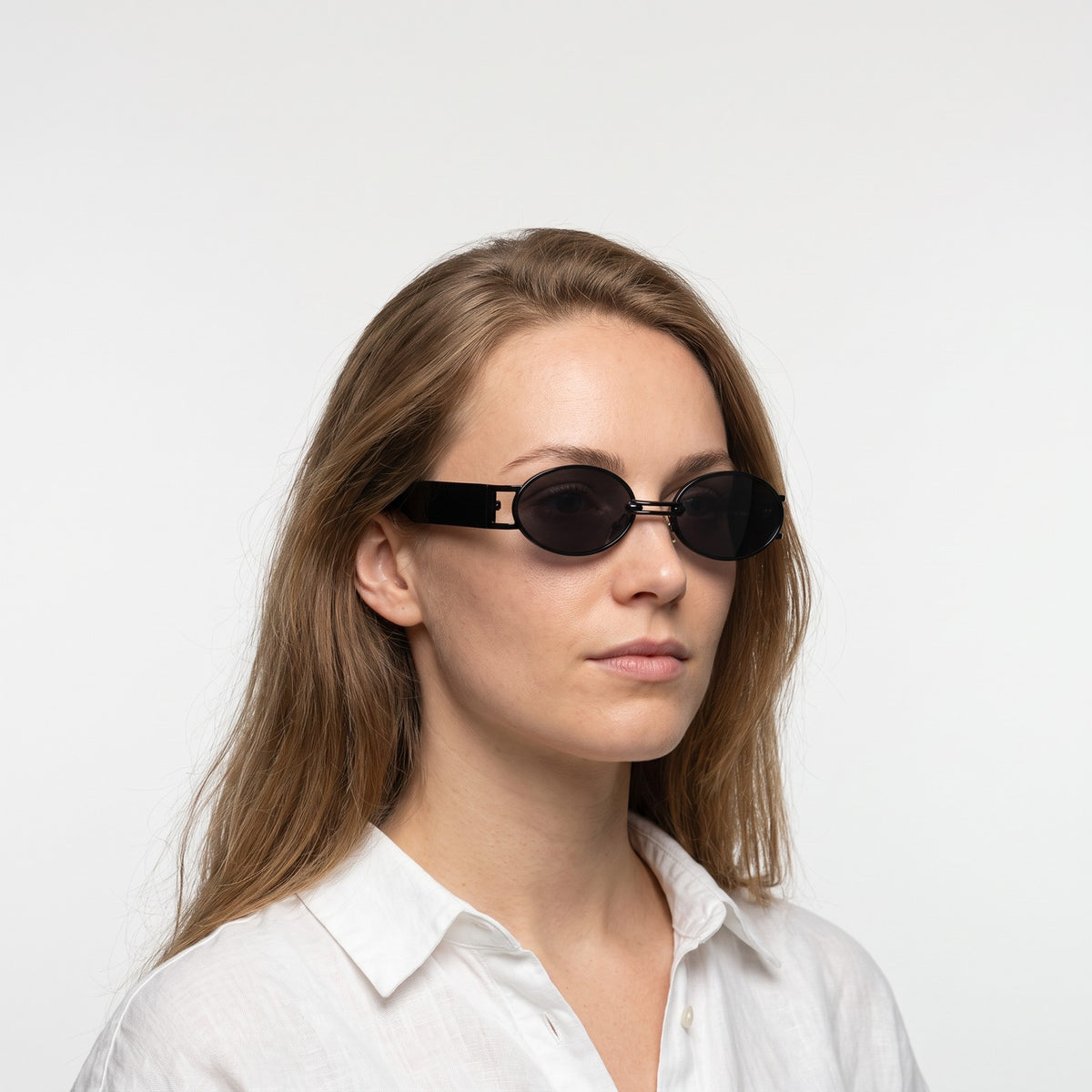 Woman in a white linen shirt wearing Monte Carlo black oval sunglasses with dark grey lenses · Velezeco #opt1_3