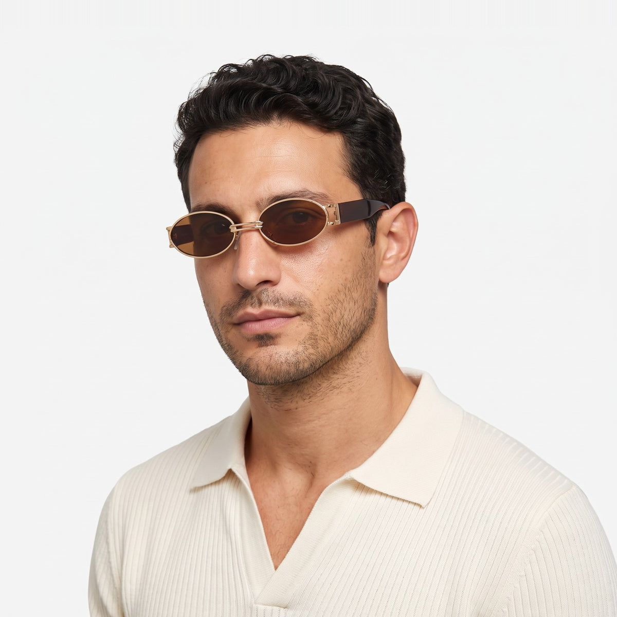 Man in a cream knit polo wearing Monte Carlo gold oval sunglasses with brown lenses and brown temples · Velezeco #opt1_1