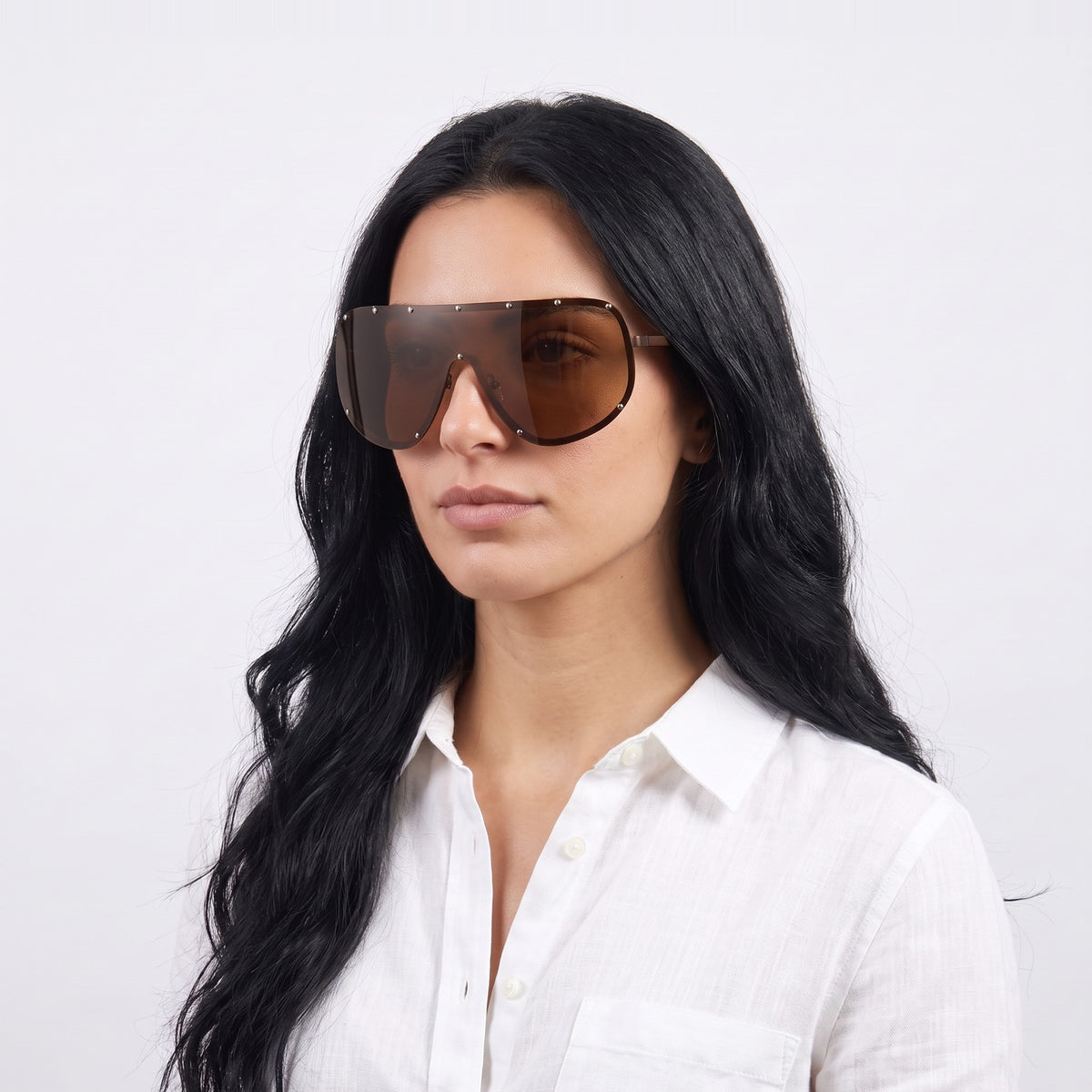 Woman in a white linen shirt wearing Mykonos shield sunglasses with brown studded rim and brown lens — Velezeco #opt1_3