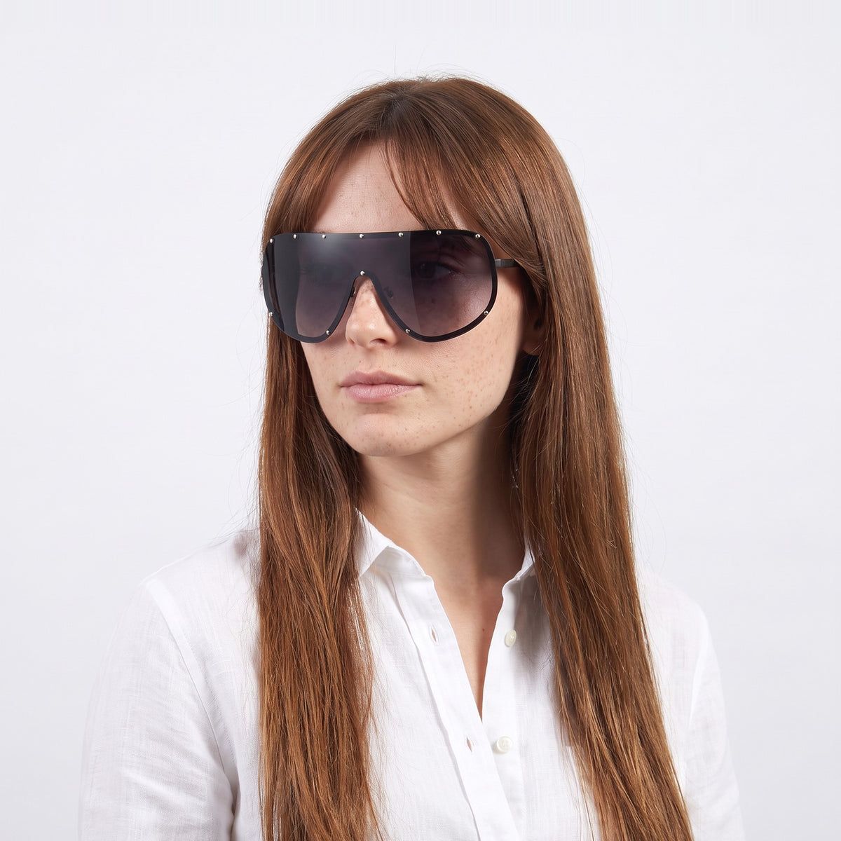 Woman in a white linen shirt wearing Mykonos shield sunglasses with black studded rim and gradient grey lens — Velezeco #opt1_2