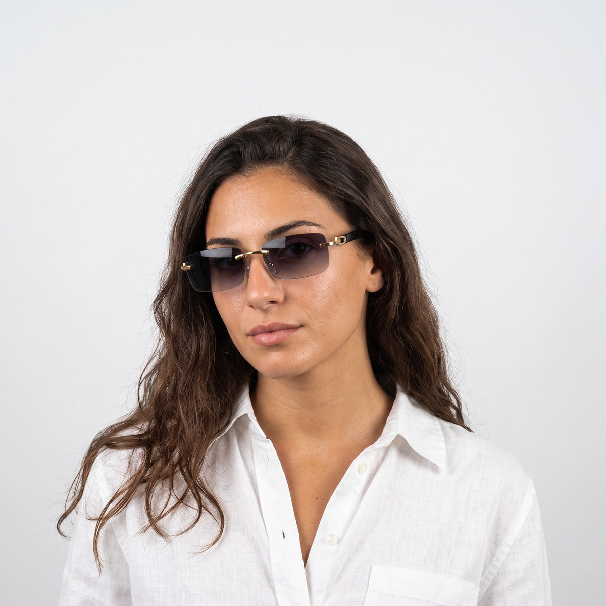 Woman in a white linen shirt wearing Phantom rimless sunglasses with grey gradient lenses and black temples · Velezeco #opt1_1