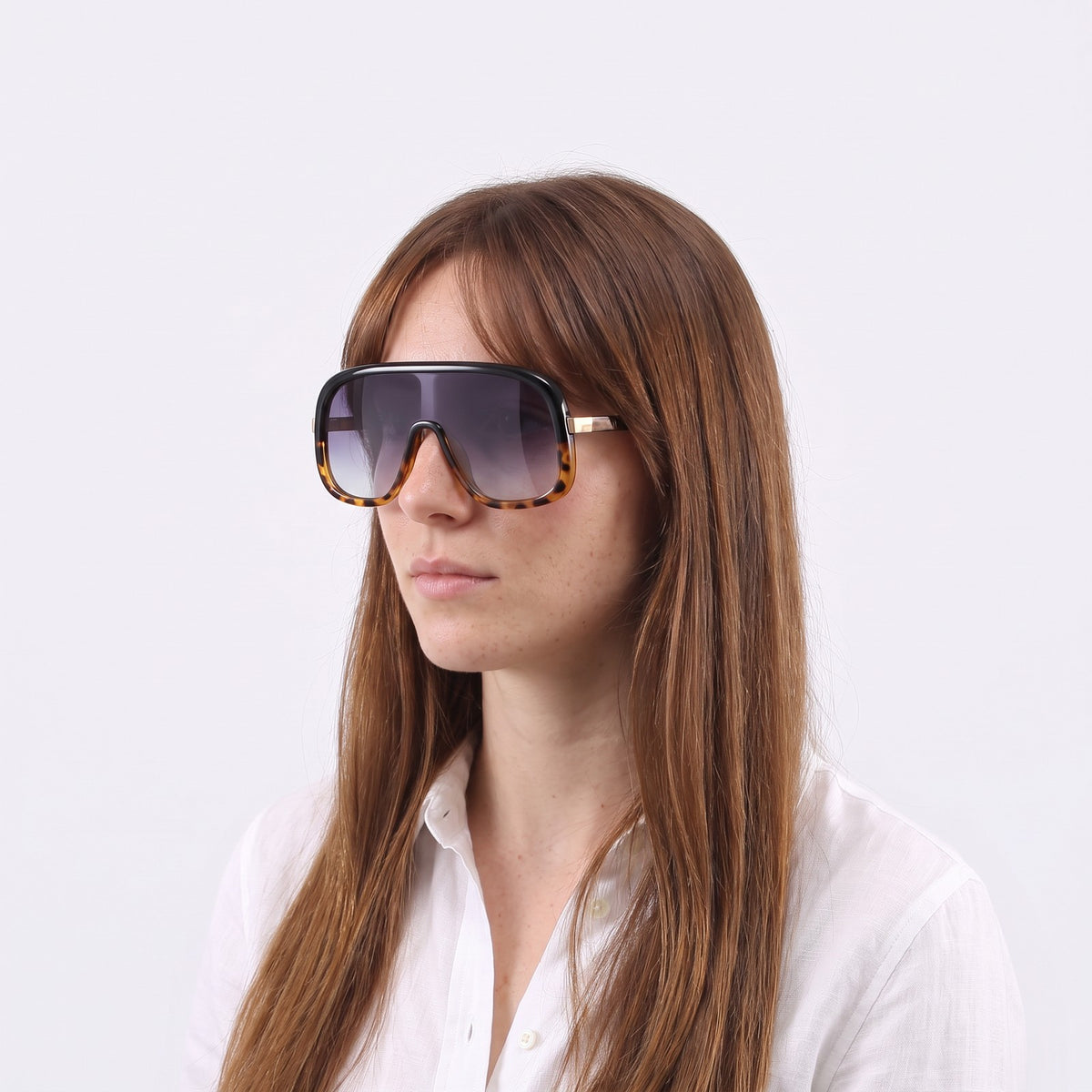 Woman in a white linen shirt wearing Saint-Tropez shield sunglasses with black and leopard two-tone frame and gradient grey lens — Velezeco #opt1_2