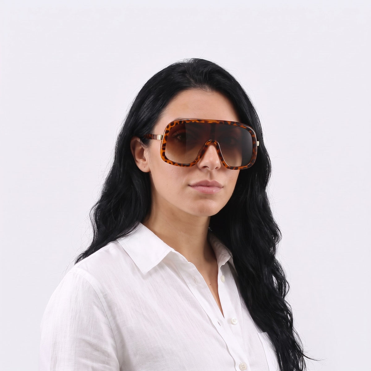 Woman in a white linen shirt wearing Saint-Tropez shield sunglasses with leopard print frame and gradient brown lens — Velezeco #opt1_3