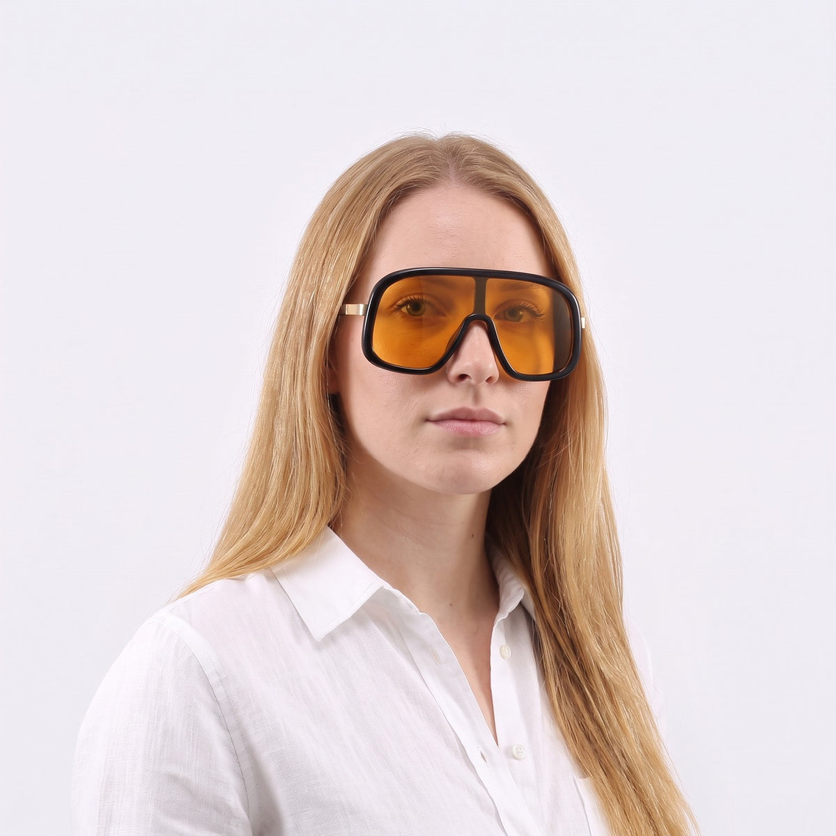 Woman in a white linen shirt wearing Saint-Tropez shield sunglasses with glossy black frame and orange lens — Velezeco #opt1_5