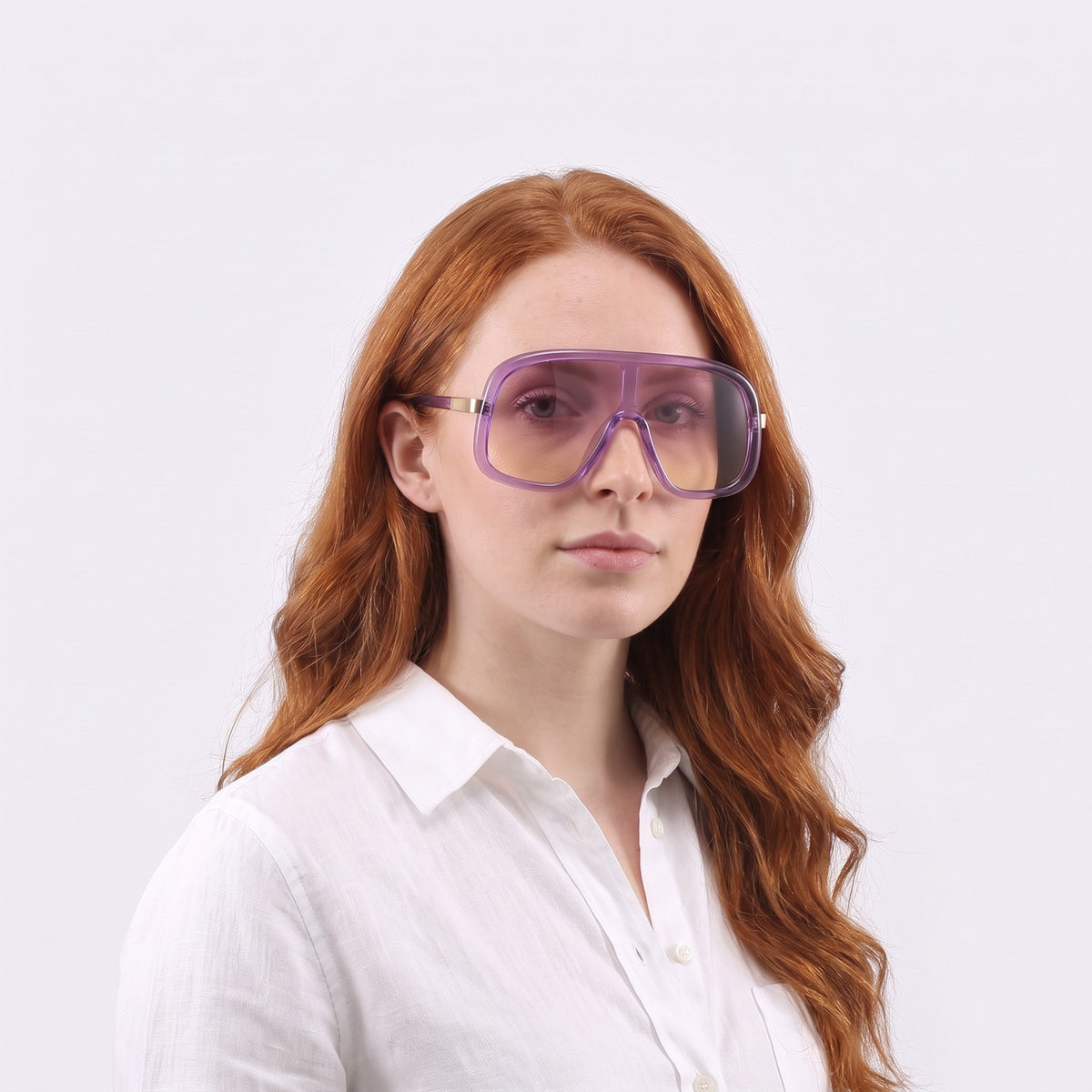 Woman in a white linen shirt wearing Saint-Tropez shield sunglasses with translucent purple frame and pink-to-yellow gradient lens — Velezeco #opt1_4