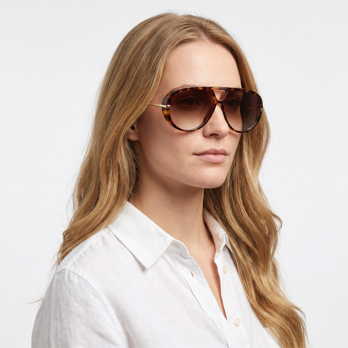 Woman in a white linen shirt wearing The Aether havana aviator sunglasses with brown gradient lenses · Velezeco #opt1_7
