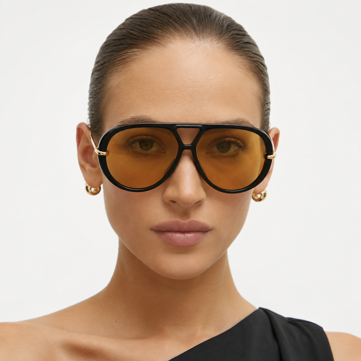 Woman wearing The Nimbus oversized black aviator sunglasses with yellow tinted lenses, triangle bridge and gold drop temples, studio portrait — Velezeco #opt1_1