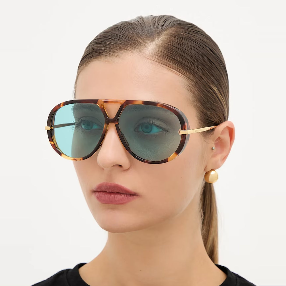 Side view of a model wearing The Nimbus tortoiseshell aviator sunglasses with blue lenses and gold drop temple — Velezeco #opt1_5