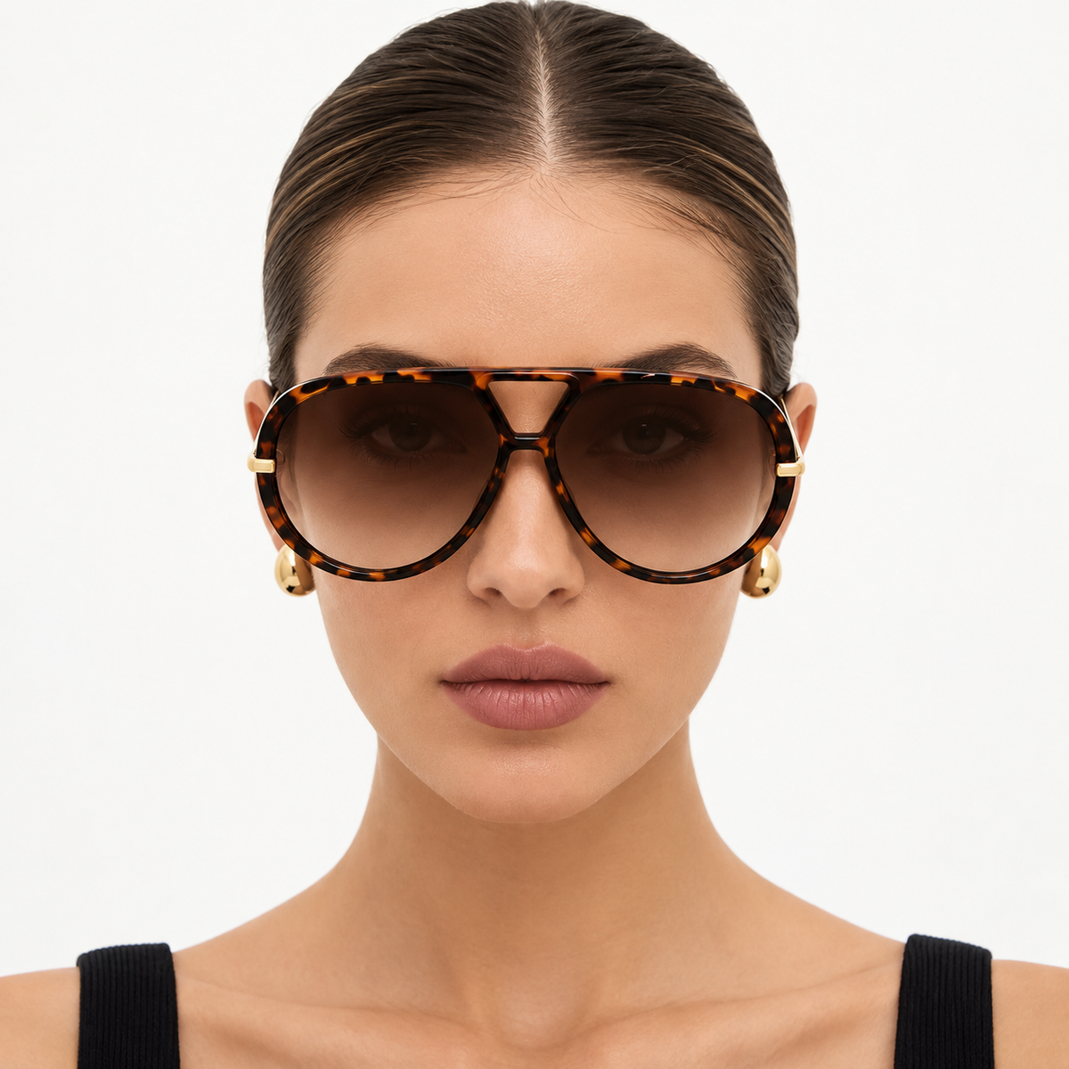 Model wearing The Nimbus oversized tortoiseshell aviator sunglasses with brown gradient lenses and gold drop temples, studio portrait — Velezeco #opt1_4