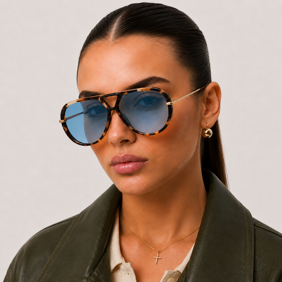 Woman wearing The Nimbus oversized tortoiseshell aviator sunglasses with blue lenses and gold metal temples by Velezeco. #opt1_5