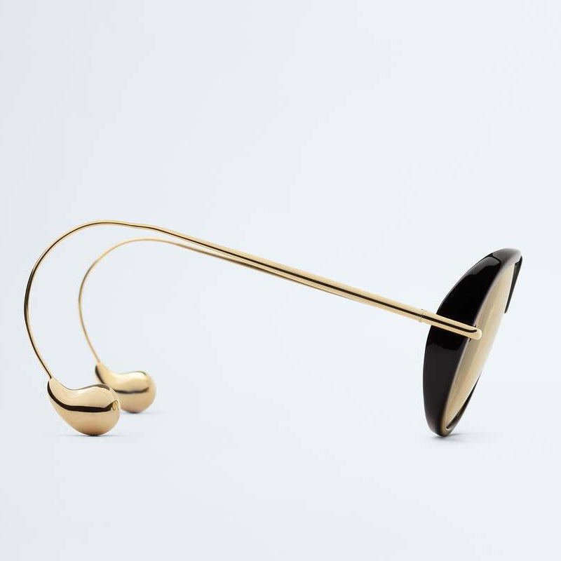 Side view of The Nimbus sunglasses featuring a black acetate frame, slim gold metal temples and signature gold drop-shaped temple tips by Velezeco. #opt1_1
