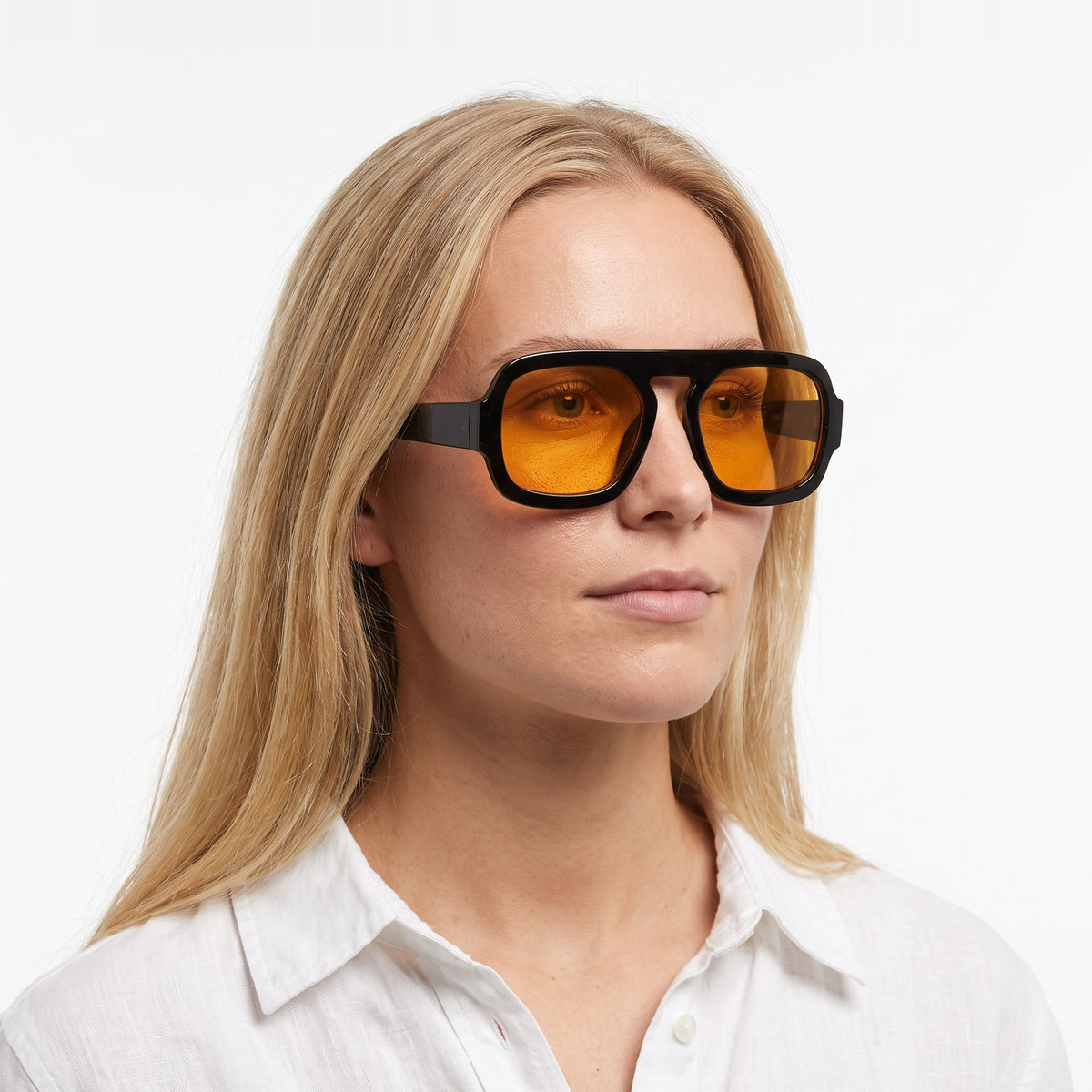 Woman in a white linen shirt wearing Vortex black square pilot sunglasses with amber yellow lenses · Velezeco #opt1_5