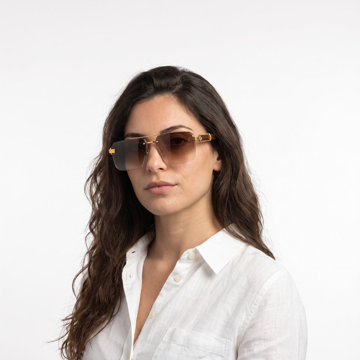 Woman in a white linen shirt wearing Aspen rimless brown gradient sunglasses with gold bridge and wood-grain temples · Velezeco #opt1_1