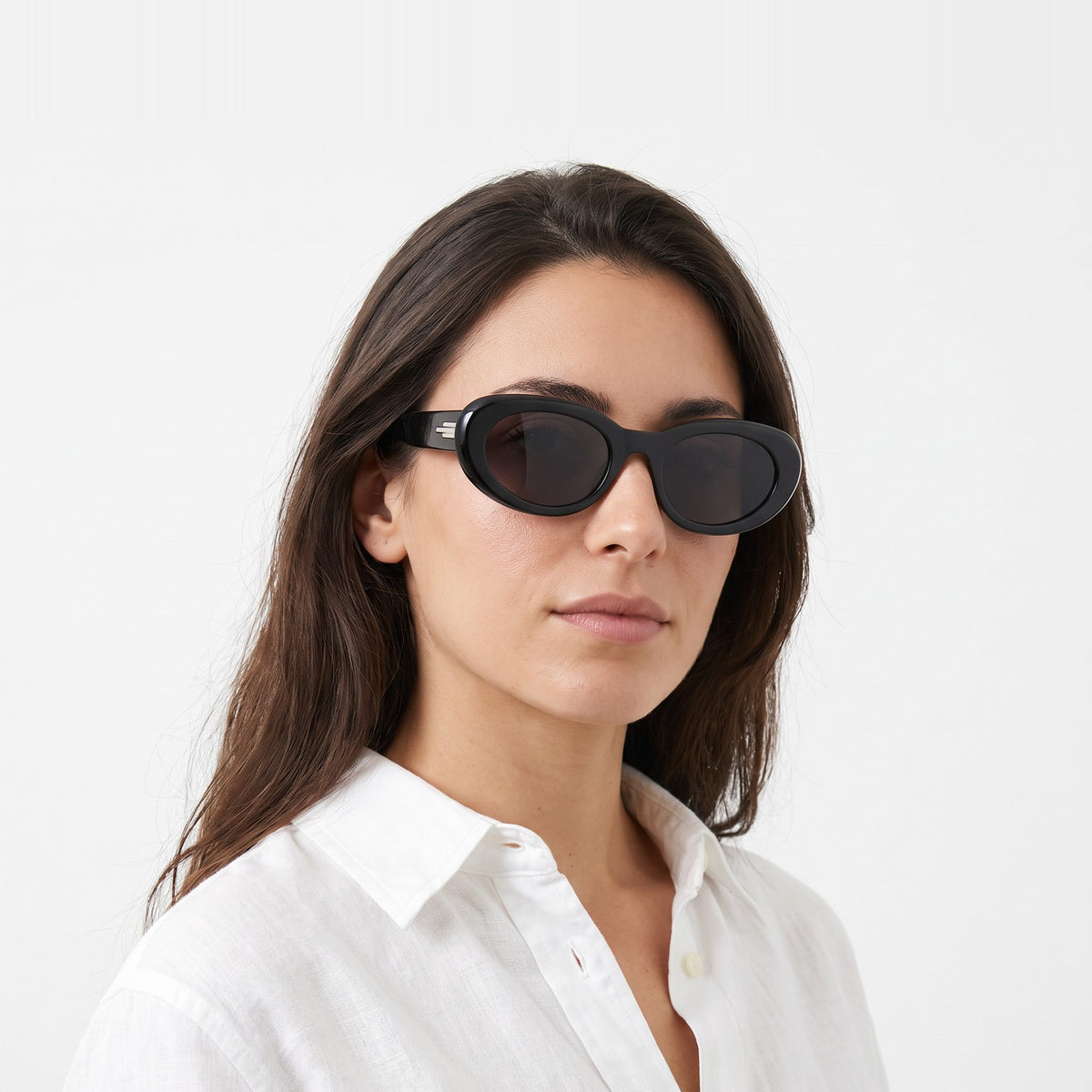 Woman in a white linen shirt wearing Belmont bold oval black sunglasses with smoke grey lenses · Velezeco #opt1_1