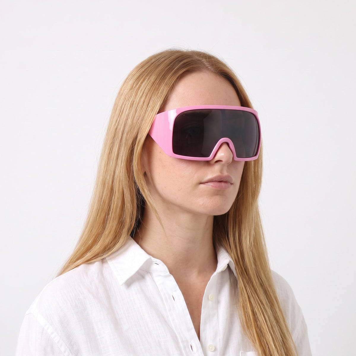 Woman in a white linen shirt wearing Berlin wrap shield sunglasses with glossy pink frame and grey lens — Velezeco #opt1_4