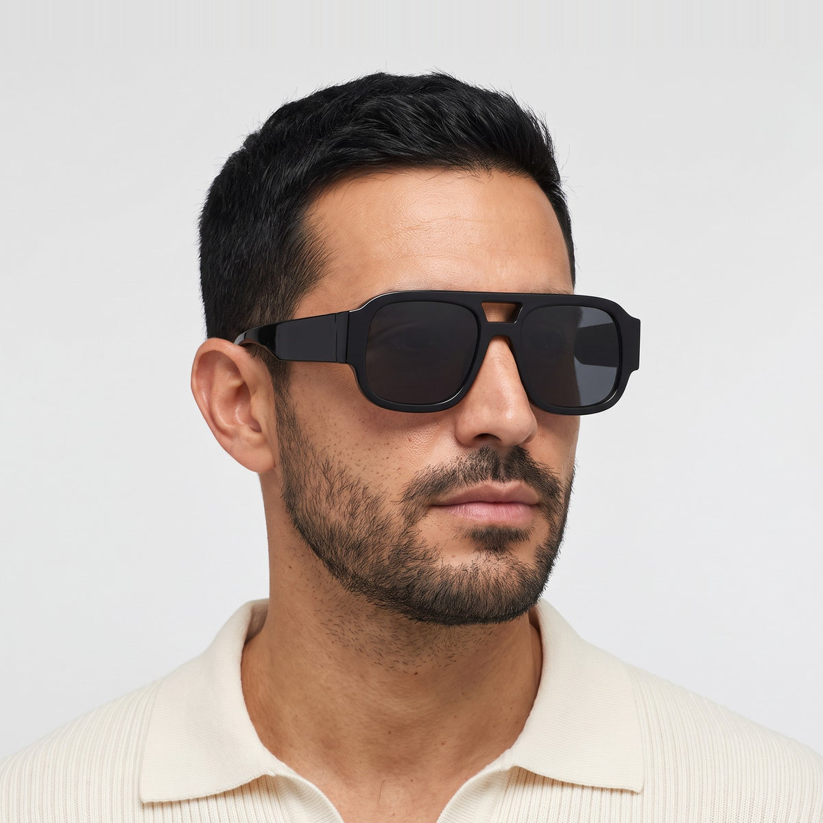 Man in a cream knit polo wearing Crimson oversized square aviator sunglasses in Black with smoke lenses - Velezeco #opt1_2