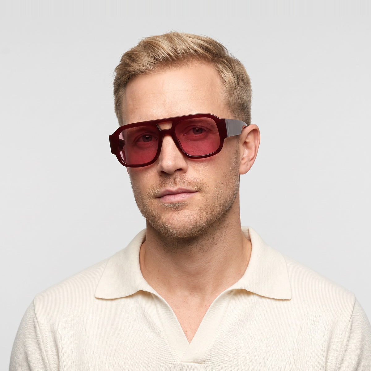 Man in a cream knit polo wearing Crimson oversized square aviator sunglasses in Red with pink lenses - Velezeco #opt1_1