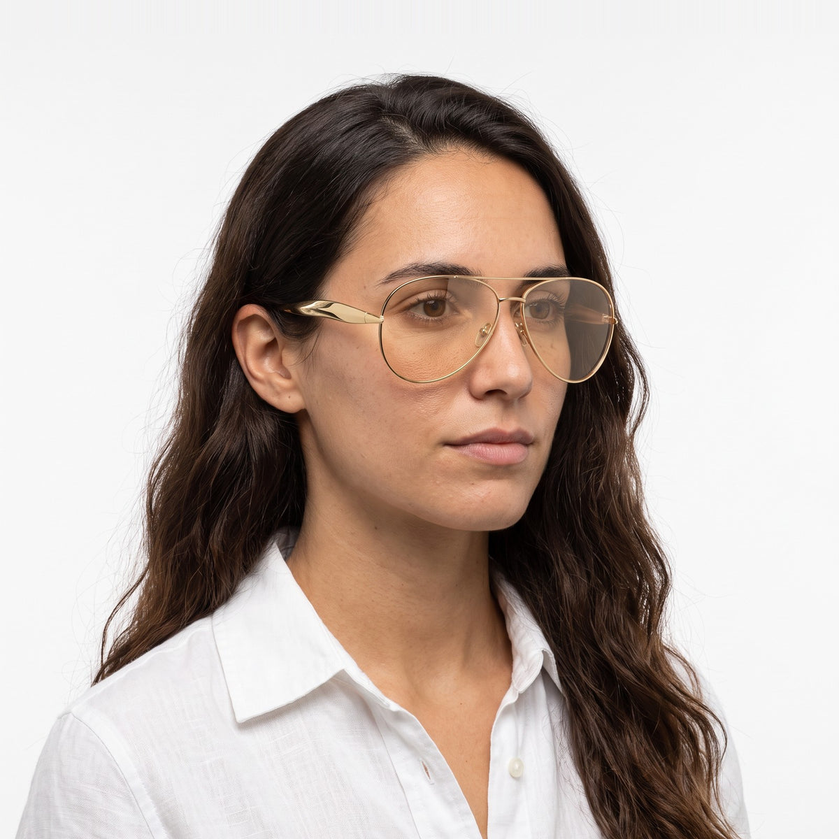 Woman in a white linen shirt wearing Duna gold aviator sunglasses with champagne lenses · Velezeco #opt1_2