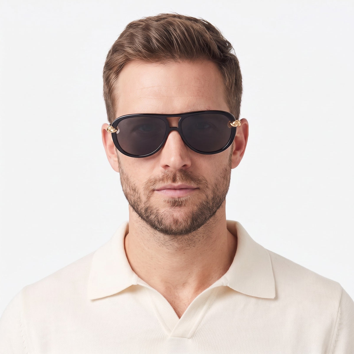 Man in a cream knit polo wearing Lunna black aviator sunglasses with dark grey lenses and gold knot temples · Velezeco #opt1_2