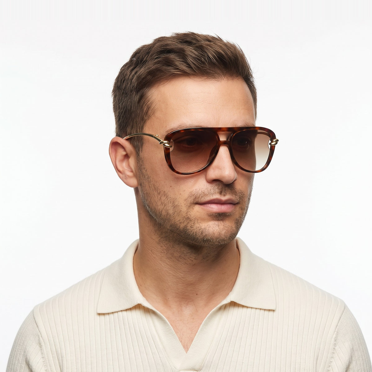 Man in a cream knit polo wearing Lunna tortoiseshell aviator sunglasses with brown gradient lenses and gold knot temples · Velezeco #opt1_3