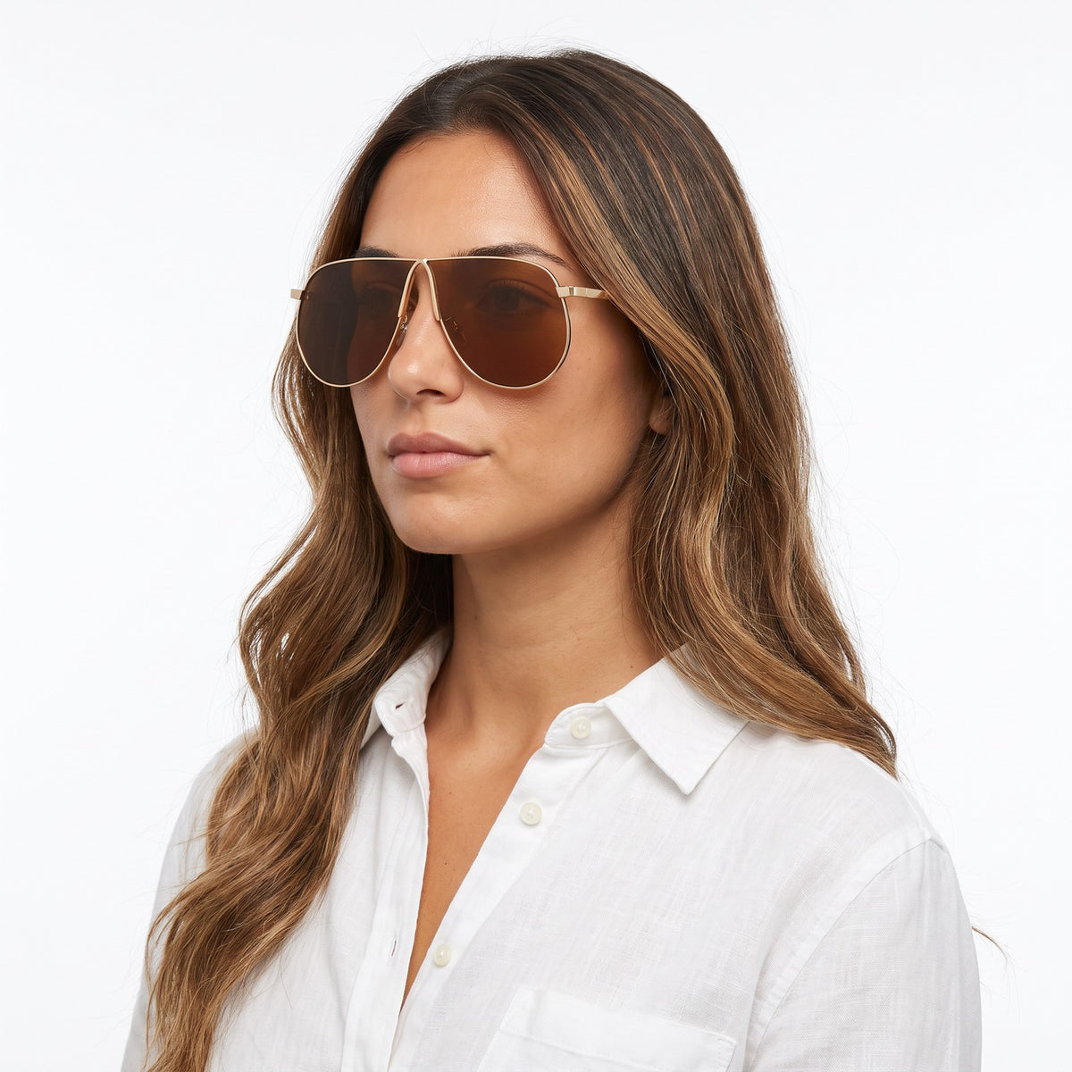 Woman in a white linen shirt wearing Mirage oversized gold shield aviator sunglasses with tea brown lenses, All tea · Velezeco #opt1_7