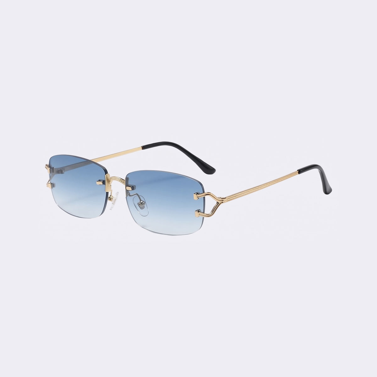 Three-quarter view of the rimless Moritz with gold metal details and gradient blue lenses showing the sculpted gold hinge — Velezeco #opt1_4