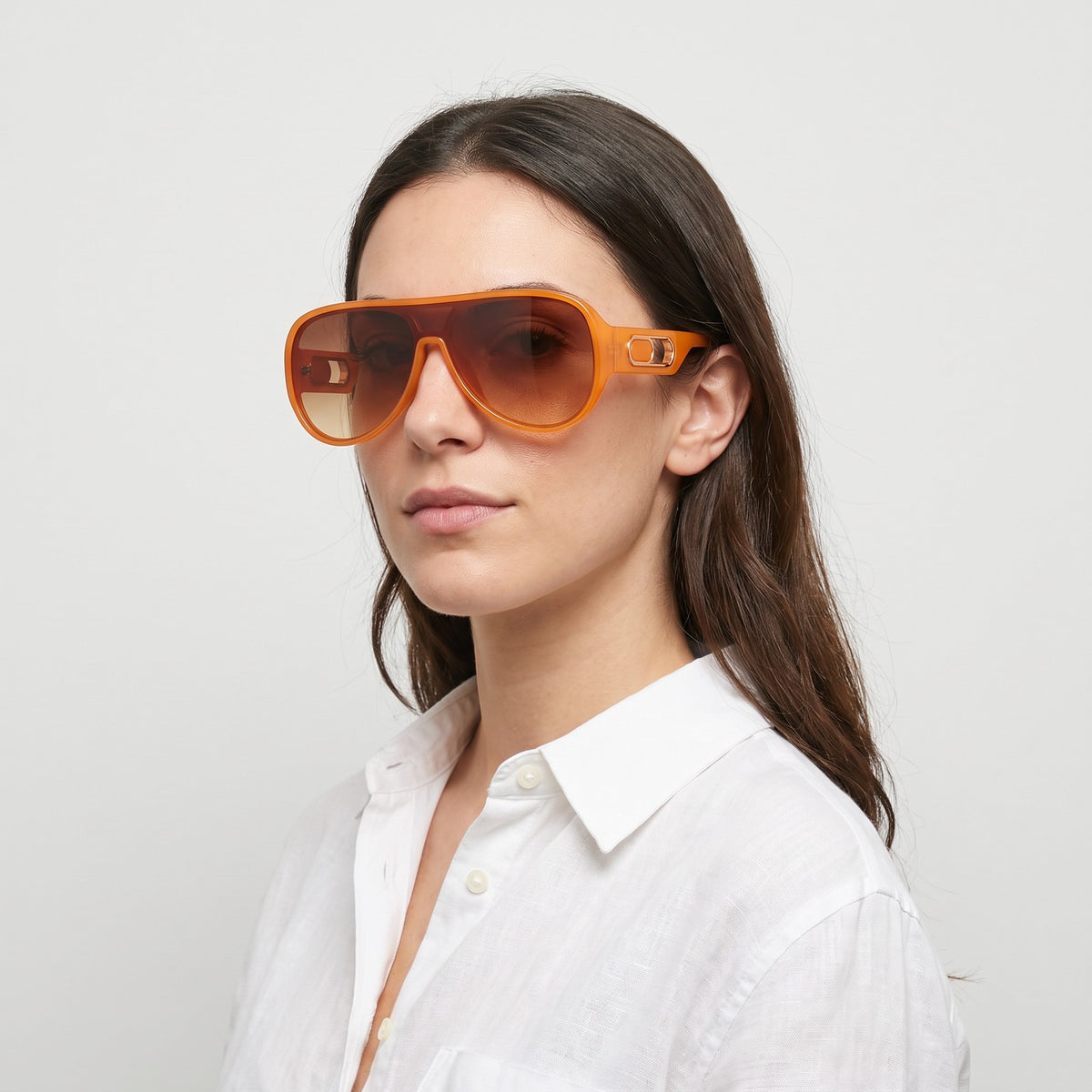 Woman in a white linen shirt wearing Portofino shield sunglasses with orange frame and brown gradient lens — Velezeco #opt1_1