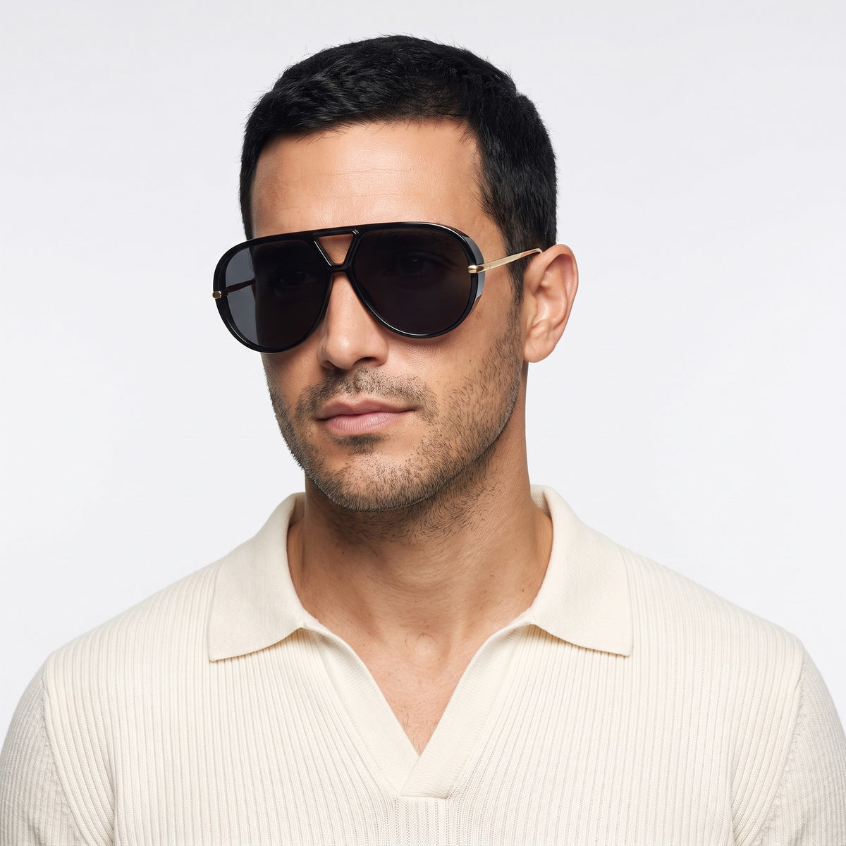 Man in a cream knit polo wearing The Aether black aviator sunglasses with black lenses · Velezeco #opt1_3
