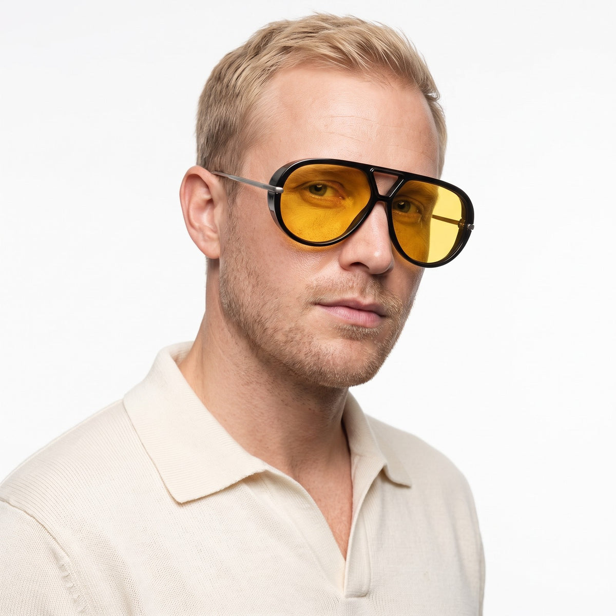 Man in a cream knit polo wearing The Aether black aviator sunglasses with yellow lenses · Velezeco #opt1_1