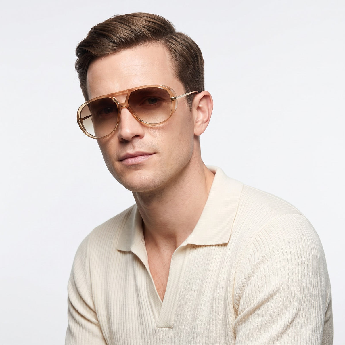 Man in a cream knit polo wearing The Aether champagne aviator sunglasses with brown gradient lenses · Velezeco #opt1_6