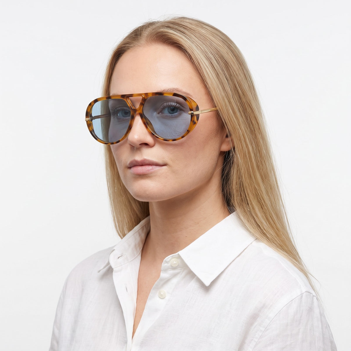 Woman in a white linen shirt wearing The Aether havana aviator sunglasses with blue lenses · Velezeco #opt1_5