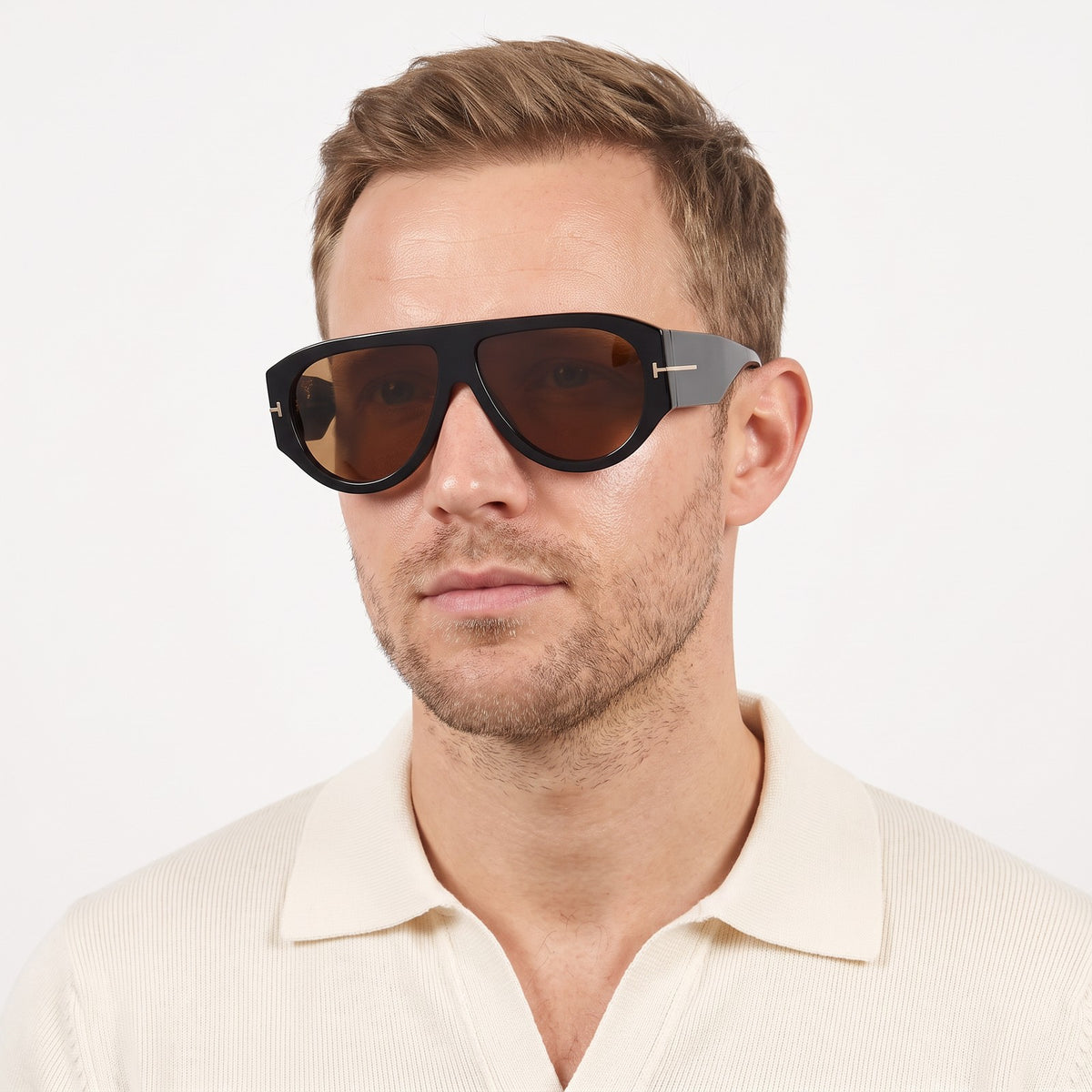 Man in a cream knit polo wearing VELEZECO Veneza black oversized aviator sunglasses with brown lenses · Brown #opt1_1