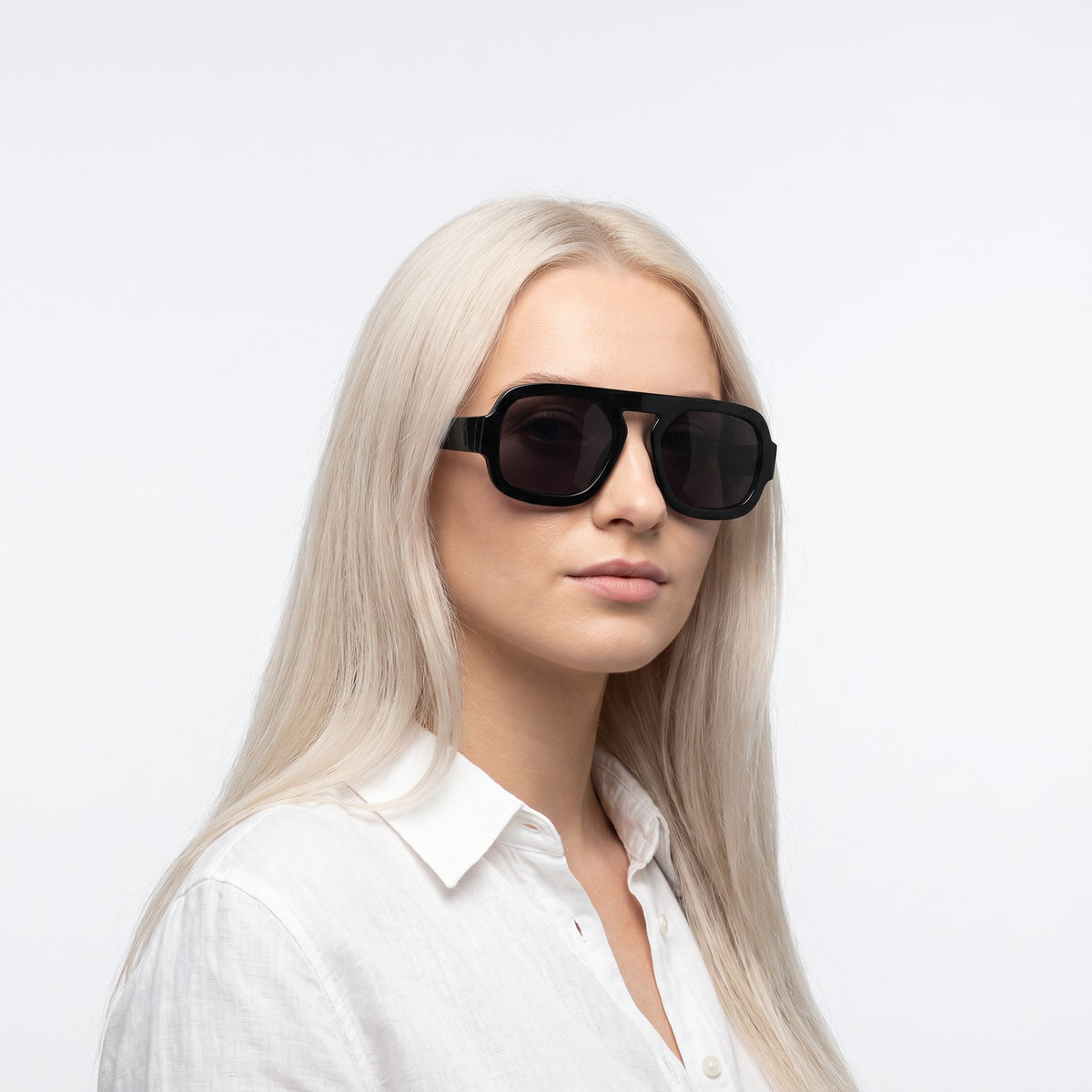 Woman in a white linen shirt wearing Vortex black square pilot sunglasses with dark grey lenses · Velezeco #opt1_3