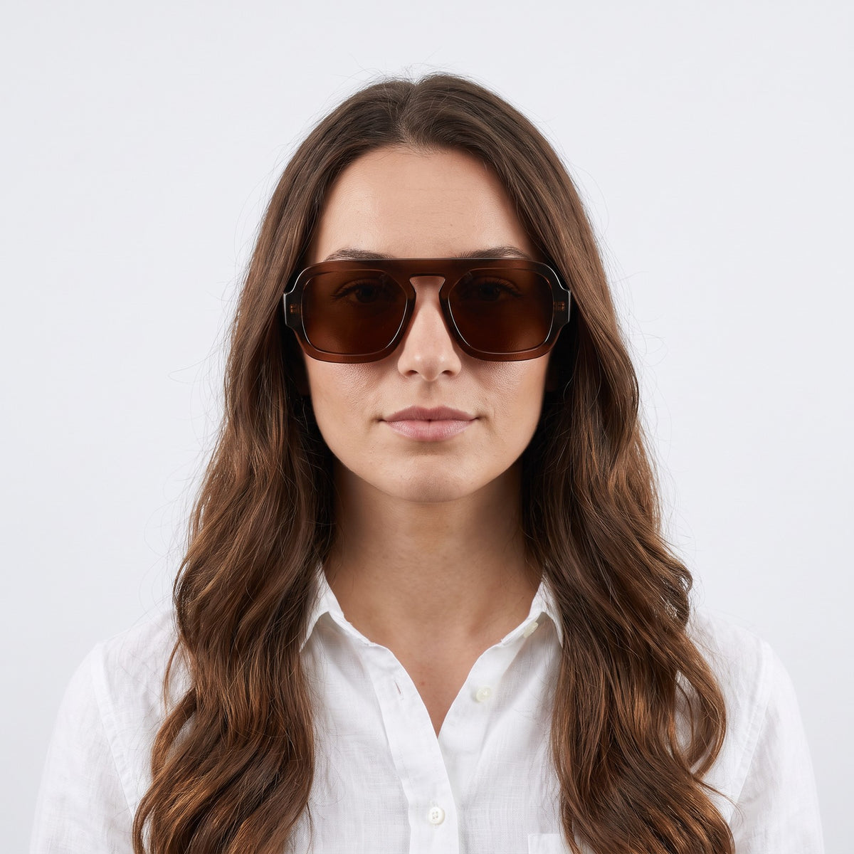 Woman in a white linen shirt wearing Vortex translucent brown square pilot sunglasses with brown lenses · Velezeco #opt1_6