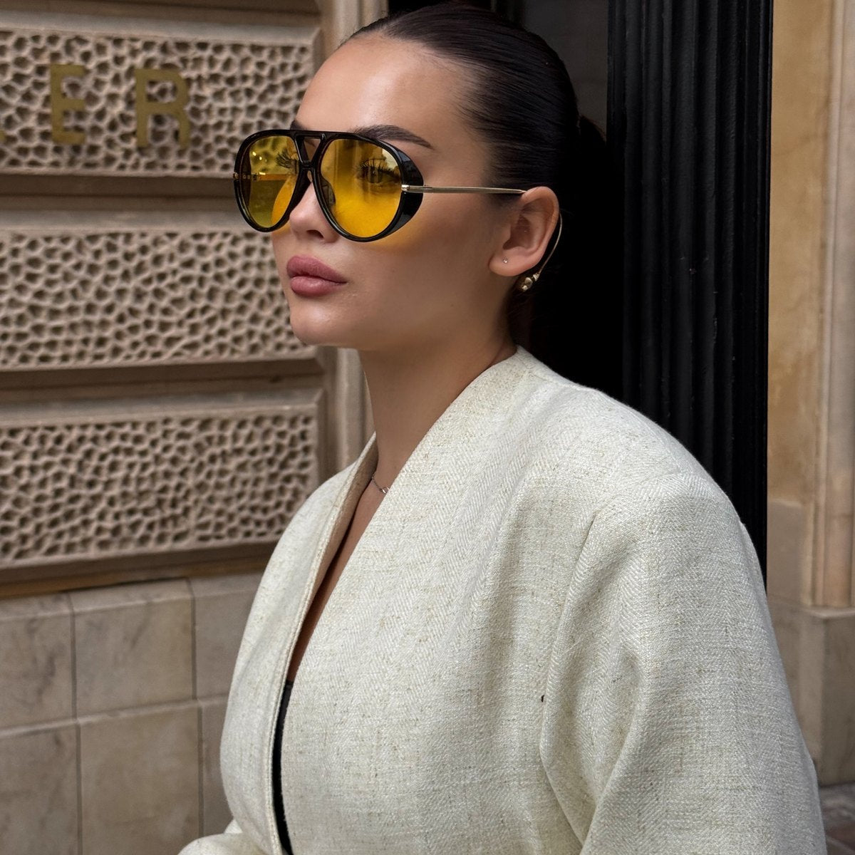 A woman wearing oversized aviator sunglasses
